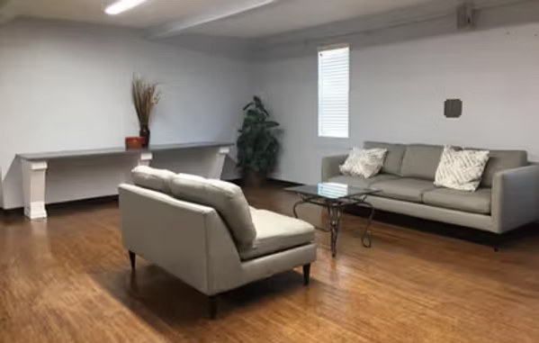 Residence hall lounge with couches and a chair