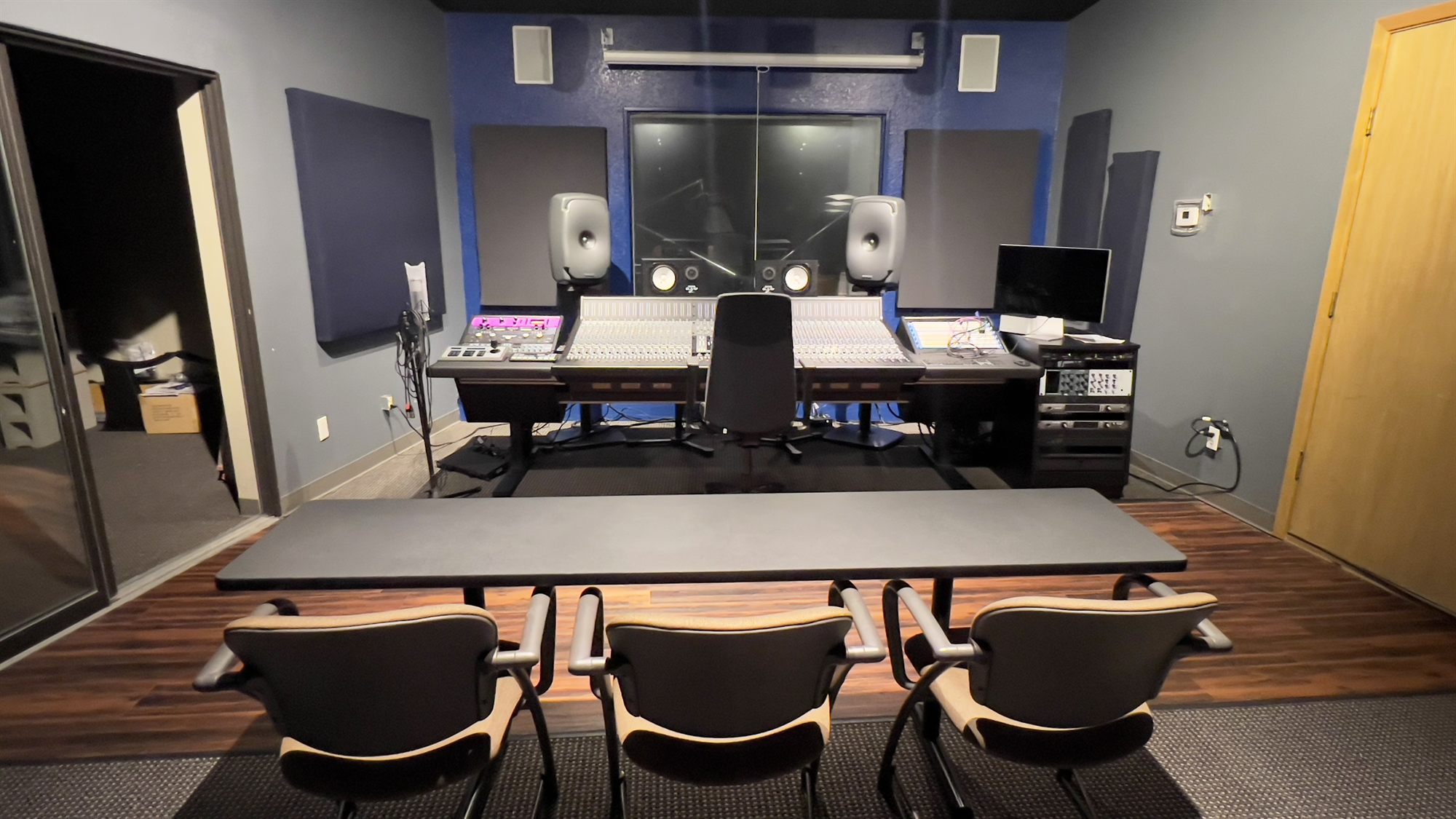 Control room with the console, Genelec monitors, and the window into the live room
